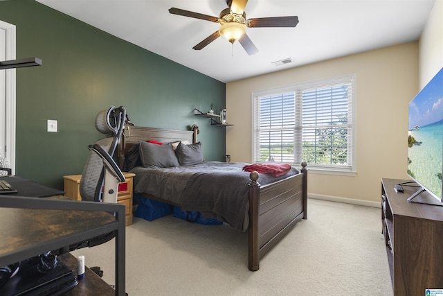 bedroom with baseboards, visible vents, a ceiling fan, and light colored carpet