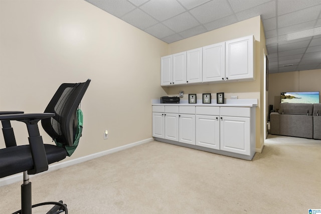 home office featuring baseboards, a drop ceiling, and light colored carpet