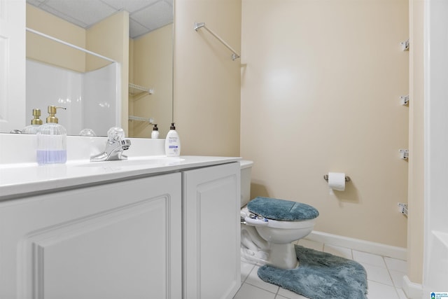full bathroom featuring tile patterned flooring, vanity, toilet, baseboards, and a paneled ceiling