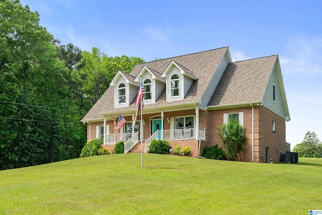 cape cod-style house featuring covered porch, brick siding, a shingled roof, and a front lawn