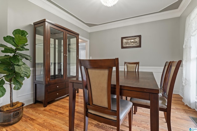 dining room featuring crown molding and light wood finished floors