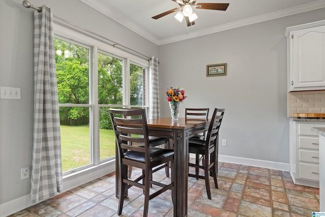 dining area featuring crown molding, baseboards, a ceiling fan, and stone finish flooring