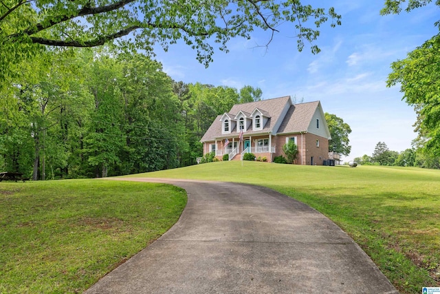 view of front of property featuring brick siding, driveway, and a front lawn