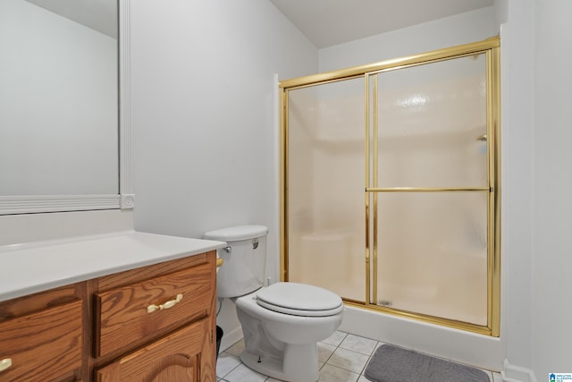 bathroom featuring vanity, toilet, tile patterned flooring, and a stall shower