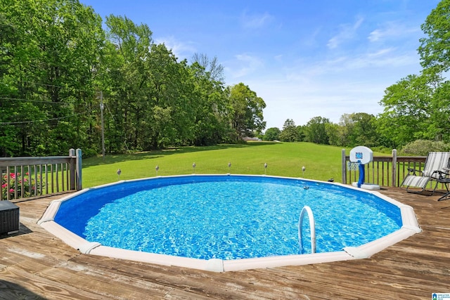 outdoor pool featuring a wooden deck and a yard