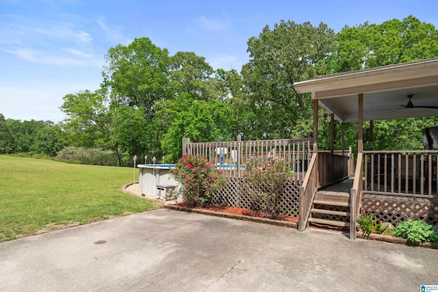 view of patio featuring a ceiling fan, an outdoor pool, and a wooden deck