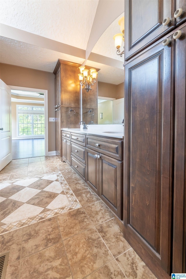 306 Oak Leaf Ln, Glencoe, AL 35905 - bathroom with visible vents, double vanity, baseboards, a sink, and a notable chandelier