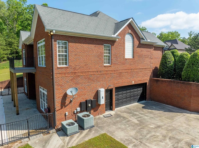 306 Oak Leaf Ln, Glencoe, AL 35905 - exterior space with a garage, a shingled roof, central AC, and brick siding