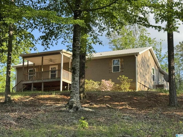 rear view of property featuring covered porch, ceiling fan, and metal roof