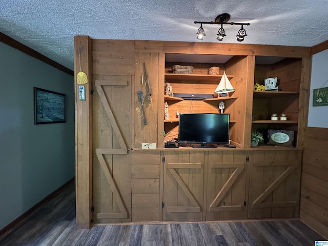 bar with a textured ceiling, baseboards, and wood finished floors
