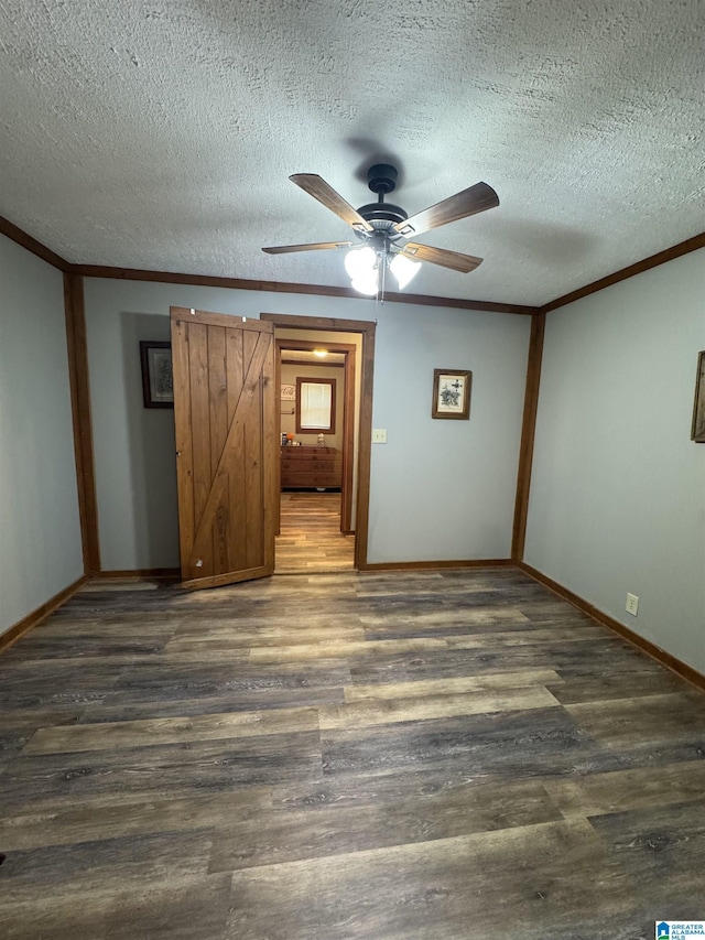 interior space featuring a ceiling fan, a textured ceiling, wood finished floors, baseboards, and ornamental molding