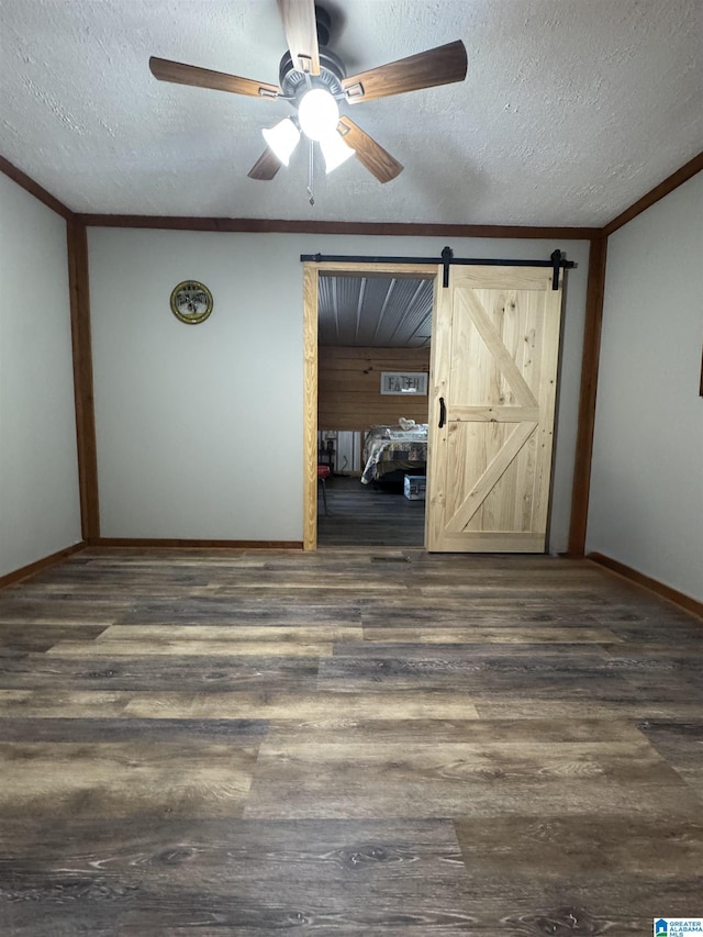 spare room with baseboards, dark wood-style flooring, a textured ceiling, and ceiling fan