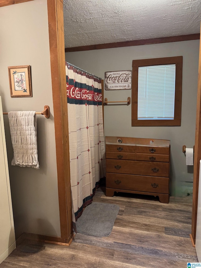 full bathroom featuring a textured ceiling, wood finished floors, and a shower with shower curtain
