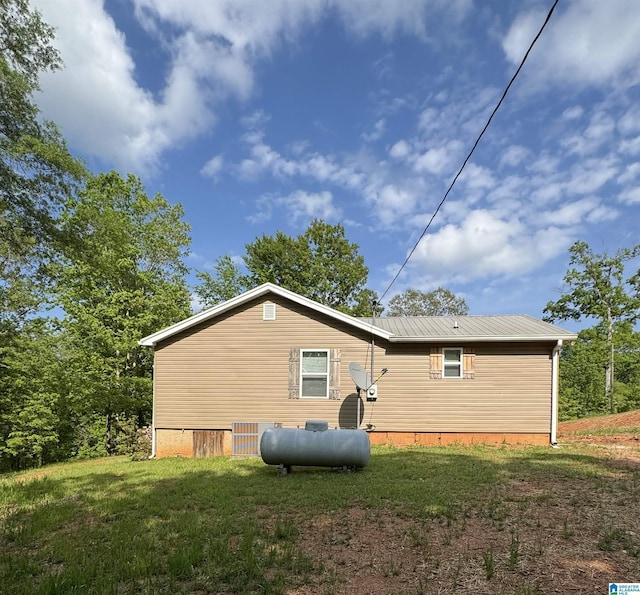 back of property with a lawn and metal roof