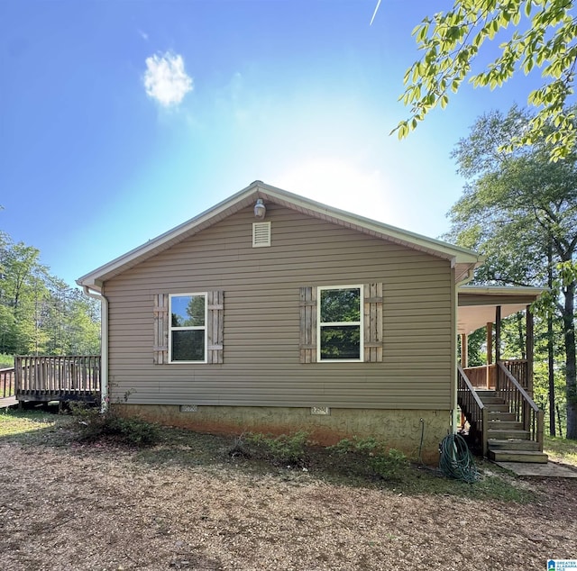 view of side of property with crawl space and a wooden deck