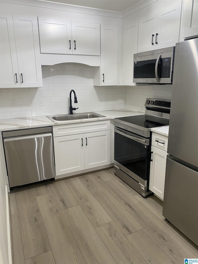 3101 Lorna Rd Unit 1626, Hoover, AL 35216 - kitchen featuring appliances with stainless steel finishes, a sink, light wood-type flooring, and white cabinets