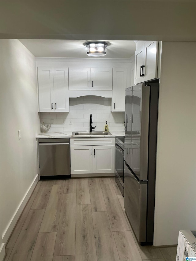 3101 Lorna Rd Unit 1626, Hoover, AL 35216 - kitchen featuring appliances with stainless steel finishes, a sink, white cabinetry, light wood-style floors, and backsplash