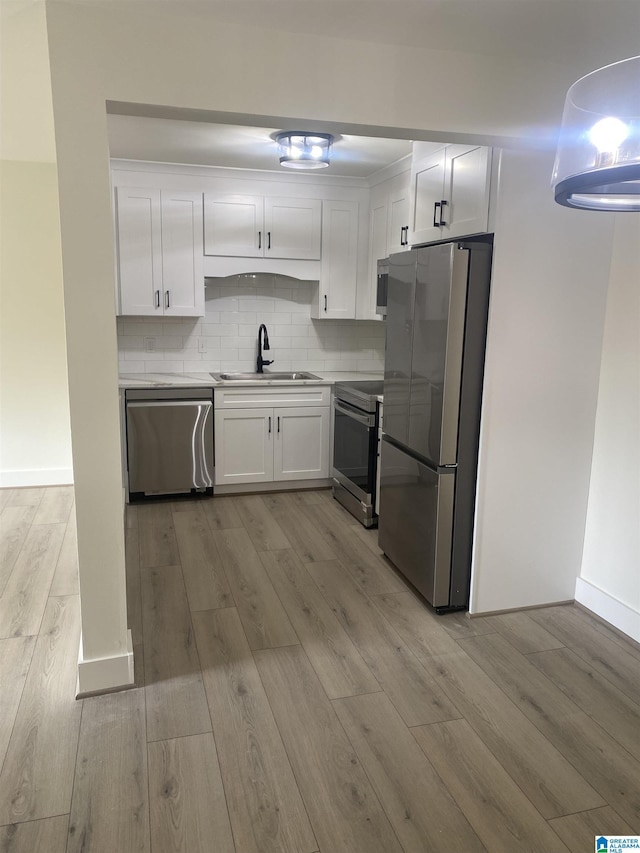 3101 Lorna Rd Unit 1626, Hoover, AL 35216 - kitchen featuring appliances with stainless steel finishes, a sink, white cabinets, light wood-style floors, and tasteful backsplash