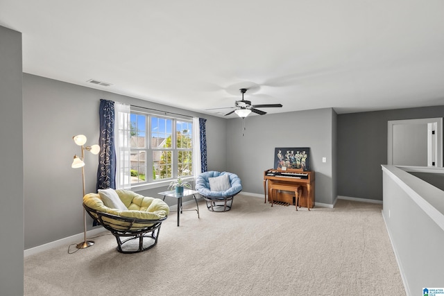 living area with visible vents, a ceiling fan, baseboards, and carpet floors