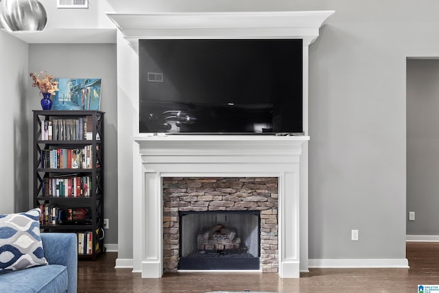 living room with baseboards, a fireplace, wood finished floors, and visible vents