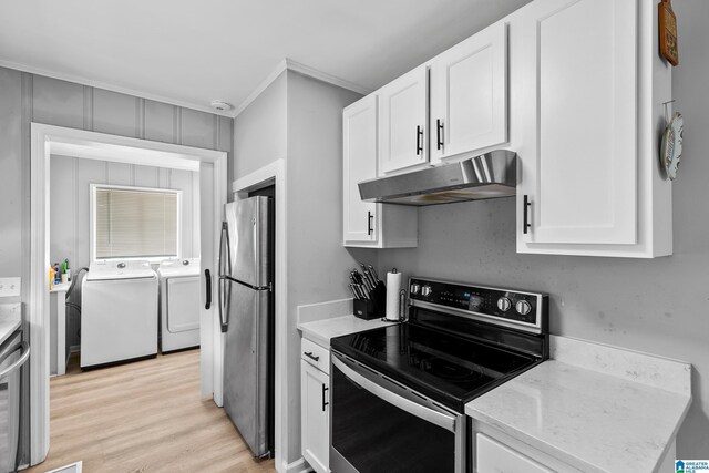 kitchen featuring appliances with stainless steel finishes, under cabinet range hood, washer and dryer, ornamental molding, and white cabinetry