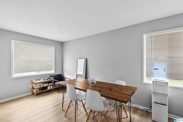 dining space with light wood-style floors and baseboards