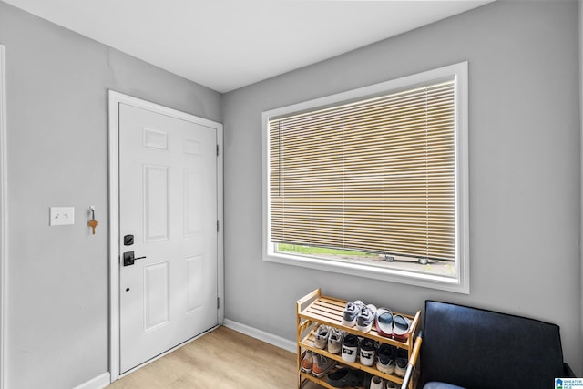 entryway with light wood finished floors and baseboards