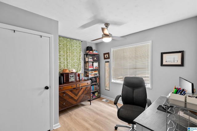 home office featuring light wood-style floors, ceiling fan, and baseboards