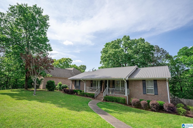 single story home featuring a front yard, a porch, metal roof, and brick siding