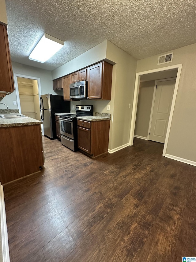 2003 Patton Creek Dr Unit 2003, Hoover, AL 35226 - kitchen with appliances with stainless steel finishes, a sink, a textured ceiling, dark wood-type flooring, and visible vents
