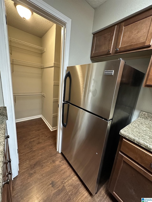 2003 Patton Creek Dr Unit 2003, Hoover, AL 35226 - kitchen featuring freestanding refrigerator, dark brown cabinets, dark wood-type flooring, a textured ceiling, and light stone counters