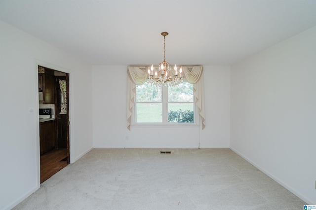 unfurnished dining area featuring baseboards, visible vents, carpet flooring, and a chandelier