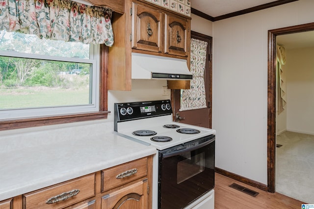 kitchen with visible vents, electric range oven, brown cabinets, ornamental molding, and under cabinet range hood