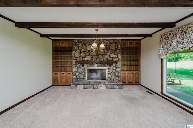 unfurnished living room with carpet floors, a stone fireplace, built in shelves, beamed ceiling, and visible vents