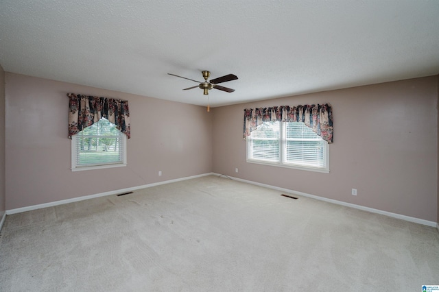 spare room with carpet flooring, ceiling fan, and baseboards