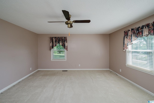 unfurnished room with baseboards, ceiling fan, carpet, and a textured ceiling