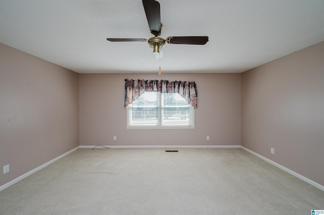 unfurnished room with baseboards, ceiling fan, light carpet, and visible vents