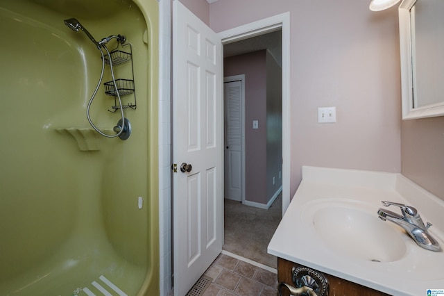 full bathroom with vanity, baseboards, walk in shower, and tile patterned floors