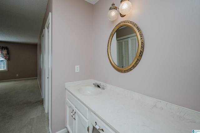 bathroom featuring a textured ceiling, baseboards, and vanity