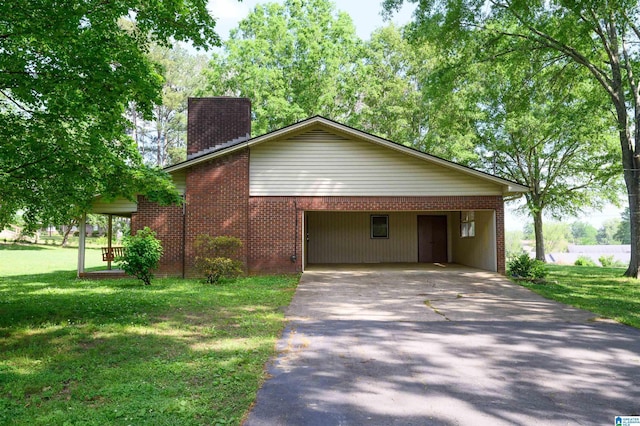 view of front of home featuring brick siding, a front yard, a chimney, a carport, and driveway