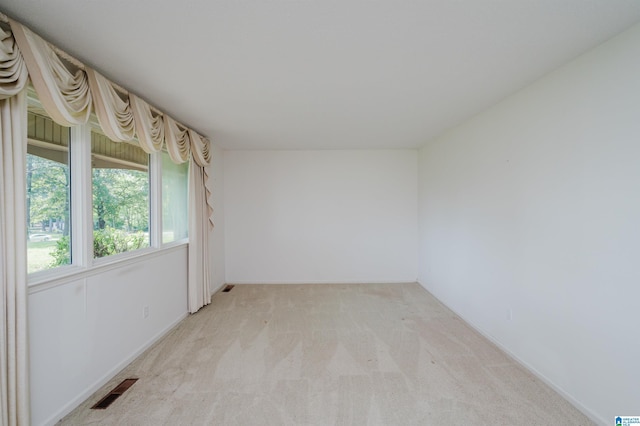 unfurnished room with visible vents and light carpet