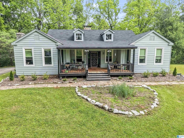 view of front of house with covered porch, a chimney, and a front lawn
