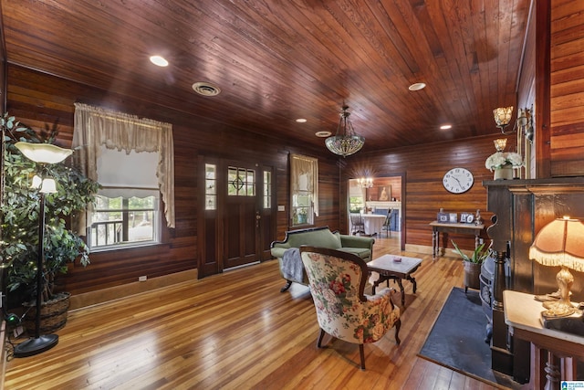 living area with recessed lighting, wood walls, hardwood / wood-style flooring, and wooden ceiling