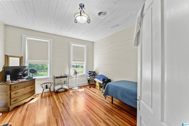 bedroom with visible vents, wooden ceiling, and hardwood / wood-style flooring