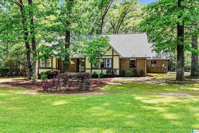 6522 Quail Run Dr, Pelham, AL 35124 - tudor home with a front lawn, roof with shingles, and brick siding