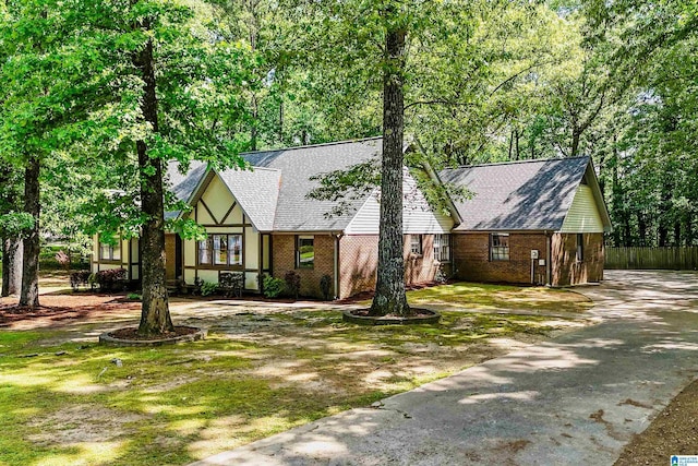 6522 Quail Run Dr, Pelham, AL 35124 - tudor-style house with brick siding, driveway, and roof with shingles