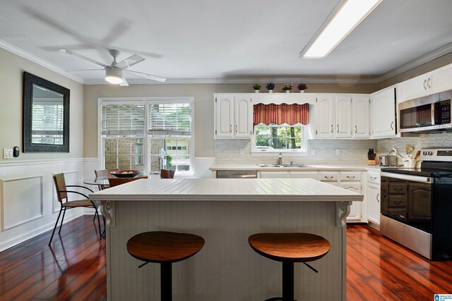 6522 Quail Run Dr, Pelham, AL 35124 - kitchen featuring stainless steel appliances, a breakfast bar area, plenty of natural light, white cabinetry, and crown molding