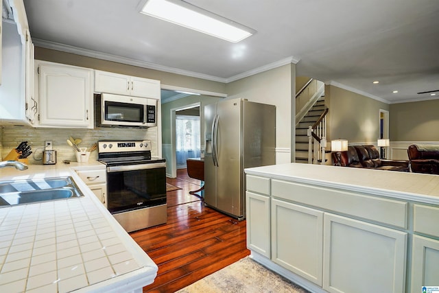 6522 Quail Run Dr, Pelham, AL 35124 - kitchen with stainless steel appliances, a sink, dark wood finished floors, tile countertops, and crown molding