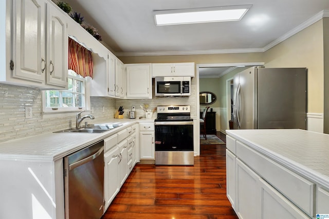 6522 Quail Run Dr, Pelham, AL 35124 - kitchen featuring appliances with stainless steel finishes, a sink, ornamental molding, white cabinets, and dark wood-style flooring