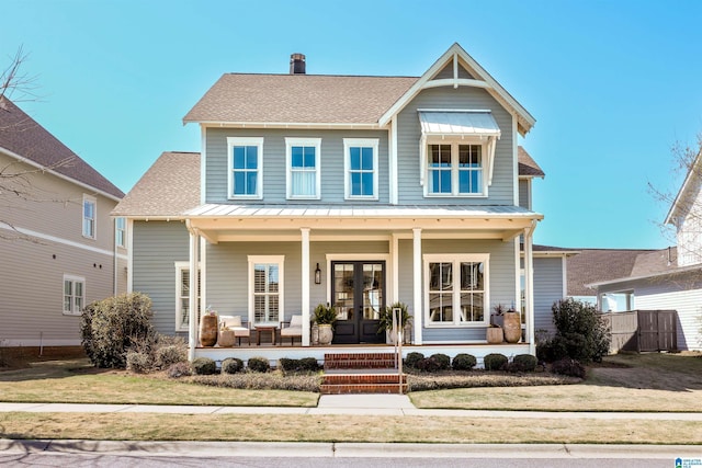 view of front facade with roof with shingles, a standing seam roof, a porch, french doors, and metal roof